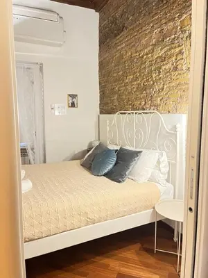 a bedroom with a white bed and a brick wall at The Ancient Wall in Rome