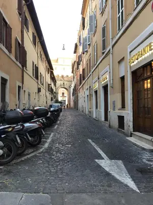 a row of motorcycles parked on a cobblestone street at The Ancient Wall in Rome