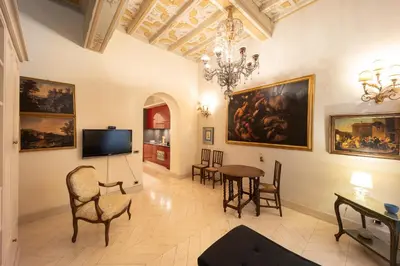 a living room with paintings on the walls and a table at Boccaccio 22 in Rome