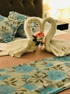 two swansrendered to look like they are kissing on a bed at KAMBAL LUXURY SUITES in Rome