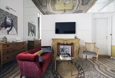 a living room with a red couch and a fireplace at Nobildonne Relais in Rome
