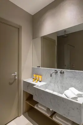 a bathroom with a large marble sink with a mirror at G55 Design Hotel in Rome