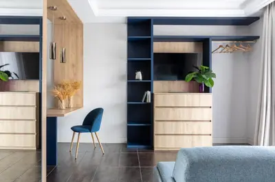 a living room with a blue chair and shelves at Patrizia Romana Palace in Rome