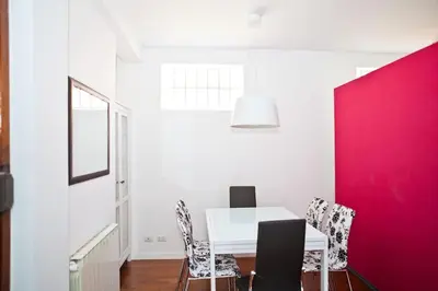 a dining room with a white table and red wall at Viale Trastevere 108 in Rome