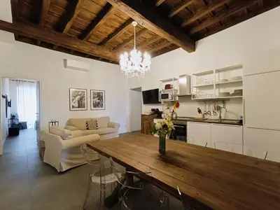 a kitchen and living room with a wooden table in a room at La tua casa a ViadelCorso in Rome
