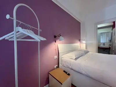 a bedroom with a large white bed and a television at Atelier San Pietro in Rome