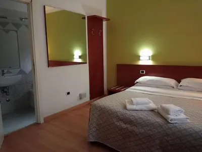 a bedroom with a bed and a sink and a mirror at La Casa Dell'Arte in Rome
