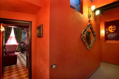 a hallway with orange walls and a mirror on the wall at Antica Dimora De Michaelis in Rome