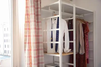 a white closet with shirts and ties in it at Raffaela's Suite & Rooms Vatican Guest House in Rome