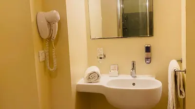 a bathroom with a sink and a phone on the wall at I Dormienti in Rome