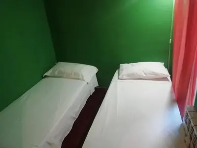 two beds in a room with a green wall at Casa di Marco a Trastevere in Rome
