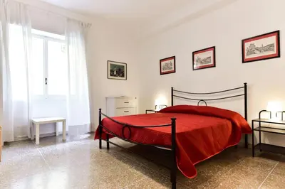 a bedroom with a bed with a red blanket at Red & White Vatican Apartment in Rome