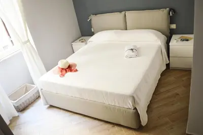 a white bed with a teddy bear sitting on it at Colosshouse guest house in Rome