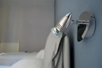 a shower head in a bathroom next to a bed at Colosshouse guest house in Rome