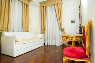 a living room with a white couch and a red chair at Royal House in Rome