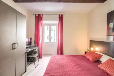 a bedroom with a red bed and a window at Hotel Mosaic in Rome
