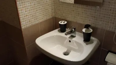 a bathroom sink with two cups on top of it at Hotel Mosaic in Rome