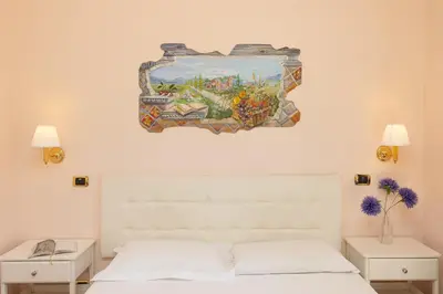 a painting above a white bed in a bedroom at Rome To Stay in Rome