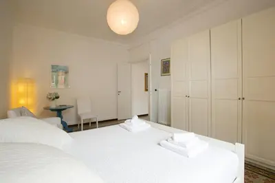 a white bedroom with a white bed and a table at Morin 27 in Rome