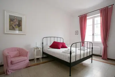 a bedroom with a bed and a chair and a window at Morin 27 in Rome