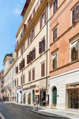 an empty city street with a large building at HT Romeo Al Babuino in Rome