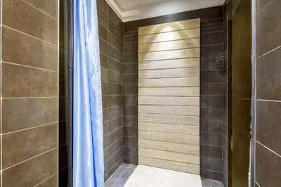 a shower with a blue curtain in a bathroom at HT Romeo Al Babuino in Rome