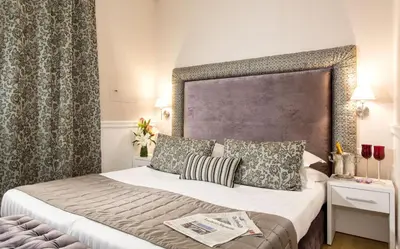 a hotel room with a bed with a large headboard at La Foresteria Luxury Suites in Rome