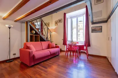 a living room with a red couch and a table at Colosseum romantic loft in Rome