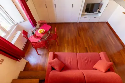a living room with a red couch and a table at Colosseum romantic loft in Rome