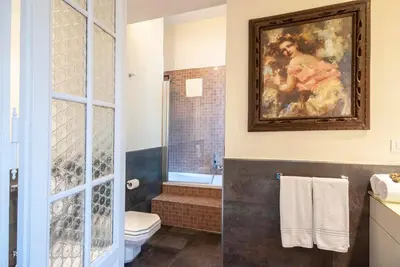 a bathroom with a painting of a woman on the wall at Bea Suites Luxury Rooms in Rome