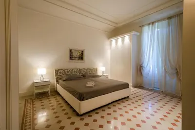 a bedroom with a large bed and two windows at Bea Suites Luxury Rooms in Rome