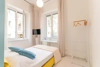 a white room with a bed and two windows at Bea Suites Luxury Rooms in Rome