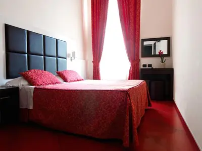 a bedroom with a bed with red sheets and a window at Cenci Bed & Breakfast Fontana di Trevi in Rome