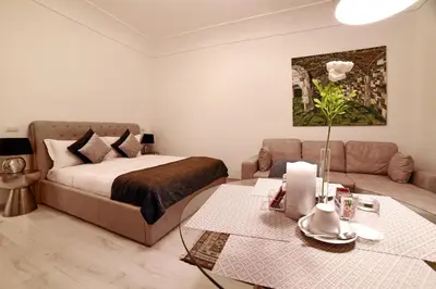 a bedroom with a bed and a couch and a table at Coladir Guest House in Rome