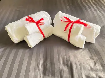 two white towels with red bows on a bed at Roman Holidays Rooms Otranto in Rome