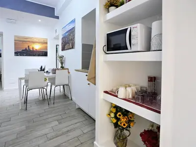 a kitchen and dining room with a table and a microwave at Relais Villa Borghese in Rome