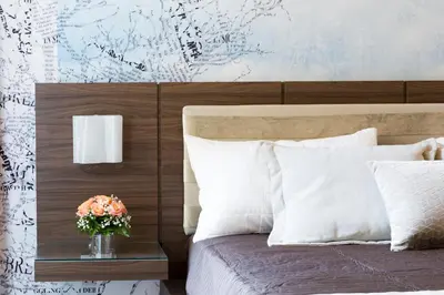 a bedroom with a bed with a vase of flowers on a table at Rhome Suites in Rome