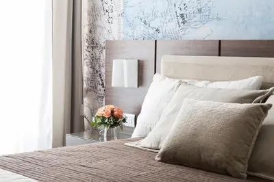 a bedroom with a bed with a vase of flowers at Rhome Suites in Rome