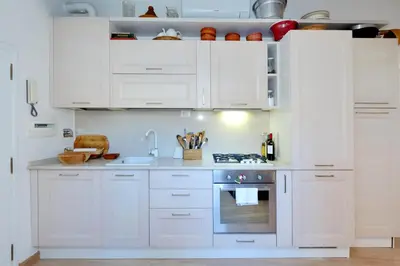 a white kitchen with white cabinets and an oven at Pantheon Charming Attic | Romeloft in Rome