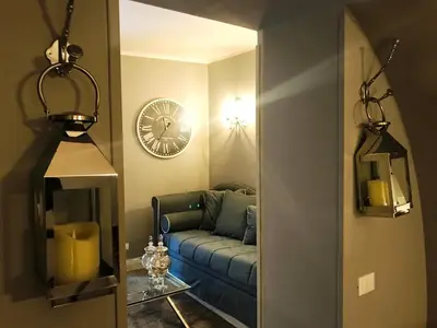 a living room with a blue couch and a clock at Di Rienzo Residences in Rome