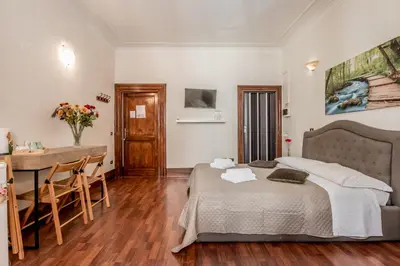 a bedroom with a bed and a table and a desk at Ariana Luxury Guest House in Rome