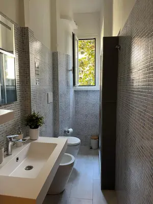 a bathroom with a sink and a toilet and a window at Domus Amica in Rome