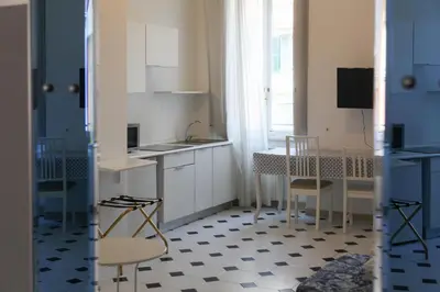 a kitchen with white cabinets and a table and chairs at Vatican Catone Apartments in Rome