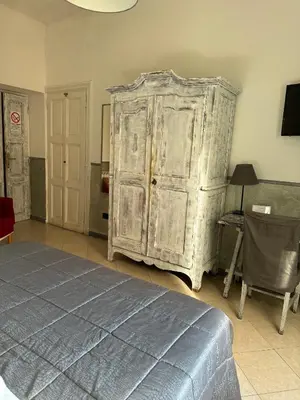 a bedroom with a large wooden cabinet and a bed at Guest House Relais Indipendenza in Rome
