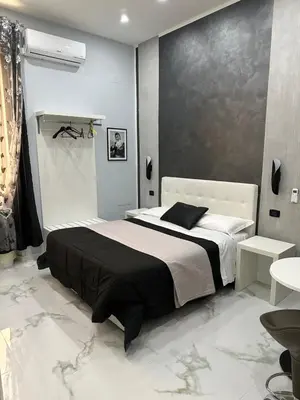 a bedroom with a black and white bed and a table at Italy Guest House in Rome