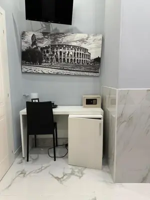 a white desk with a chair and a picture of a building at Italy Guest House in Rome