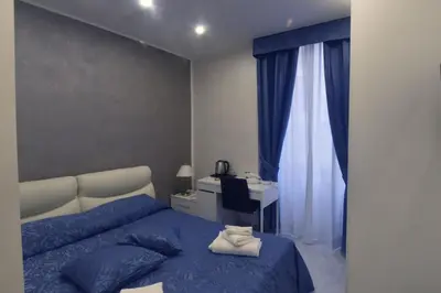 a bedroom with a bed and a desk and a window at Oscar 2 in Rome