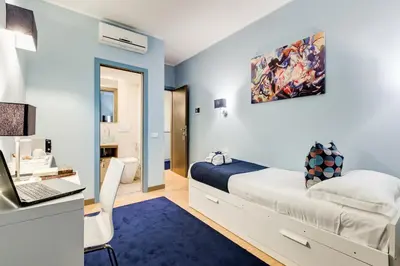 a bedroom with a bed and a desk with a laptop at Easy Budget Colosseo in Rome