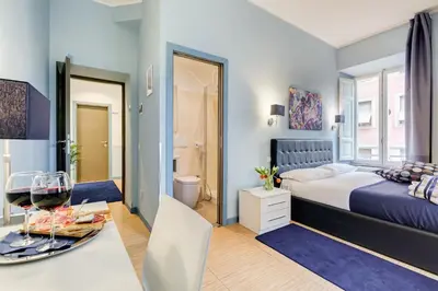 a bedroom with a bed and a table with a wine glass at Easy Budget Colosseo in Rome