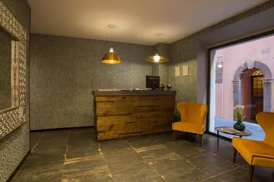 a lobby with a reception desk and two chairs at Navona Essence Hotel in Rome